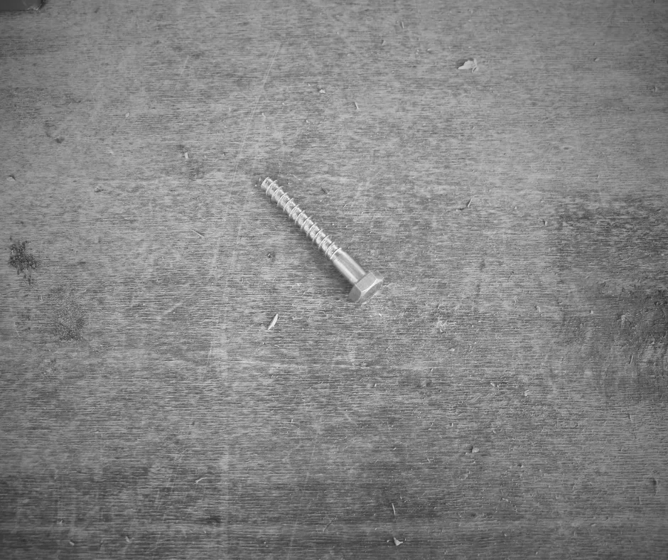 Détail de fixation métallique sur un support de chantier, illustrant la rigueur et la précision dans un projet architectural